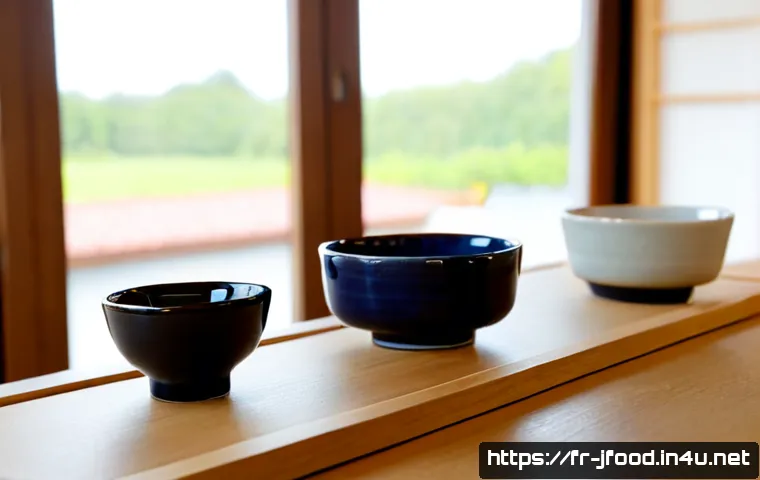 사케잔 종류와 사용법 - Photorealistic tabletop comparison of traditional Japanese sake cup types: a shallow ceramic sakazuk...